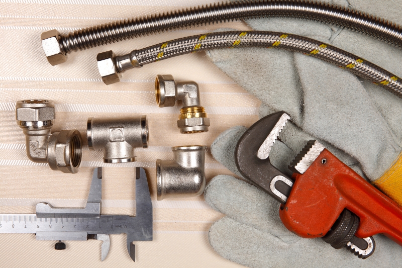 Plumber working on pipes in a Worcester Park home